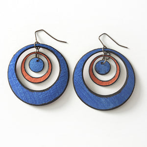 Open image in slideshow, lightweight hypoallergenic circle metallic painted rawhide dangle earrings, handmade in Wyoming, sapphire blue and copper
